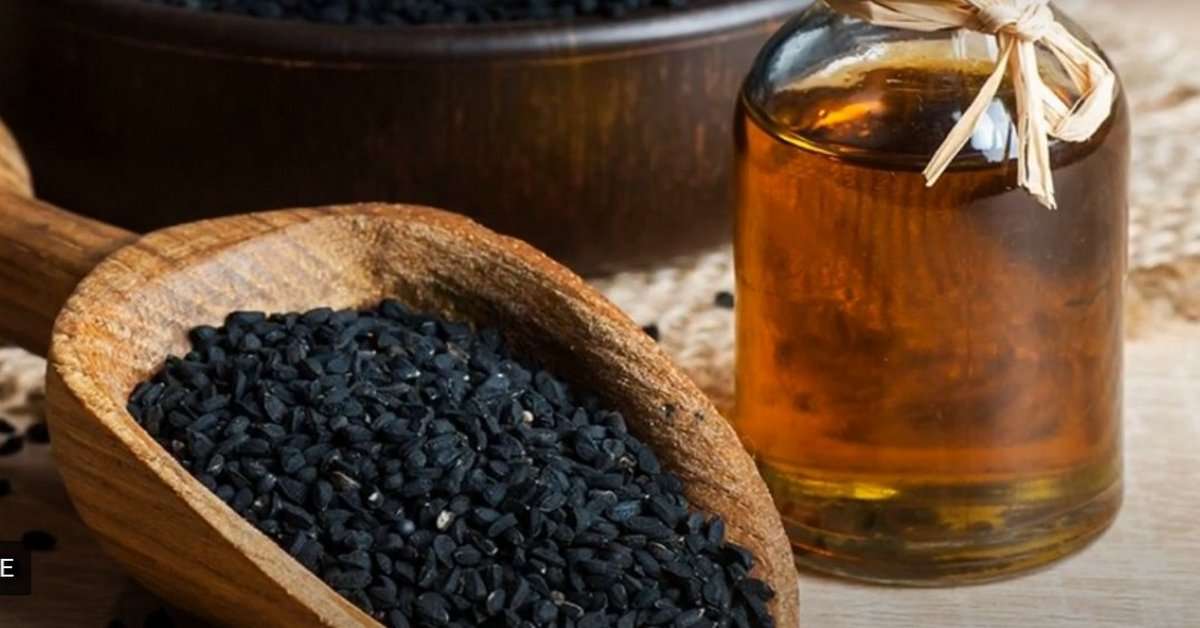 Дървена лъжица с черен кимион и стъклен буркан с отвара