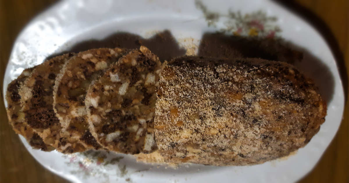 Нарязан сладък салам в продълговата чиния.