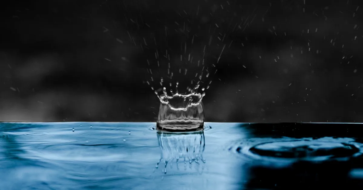Капка вода, която се разпръсква и оставя следи във водата